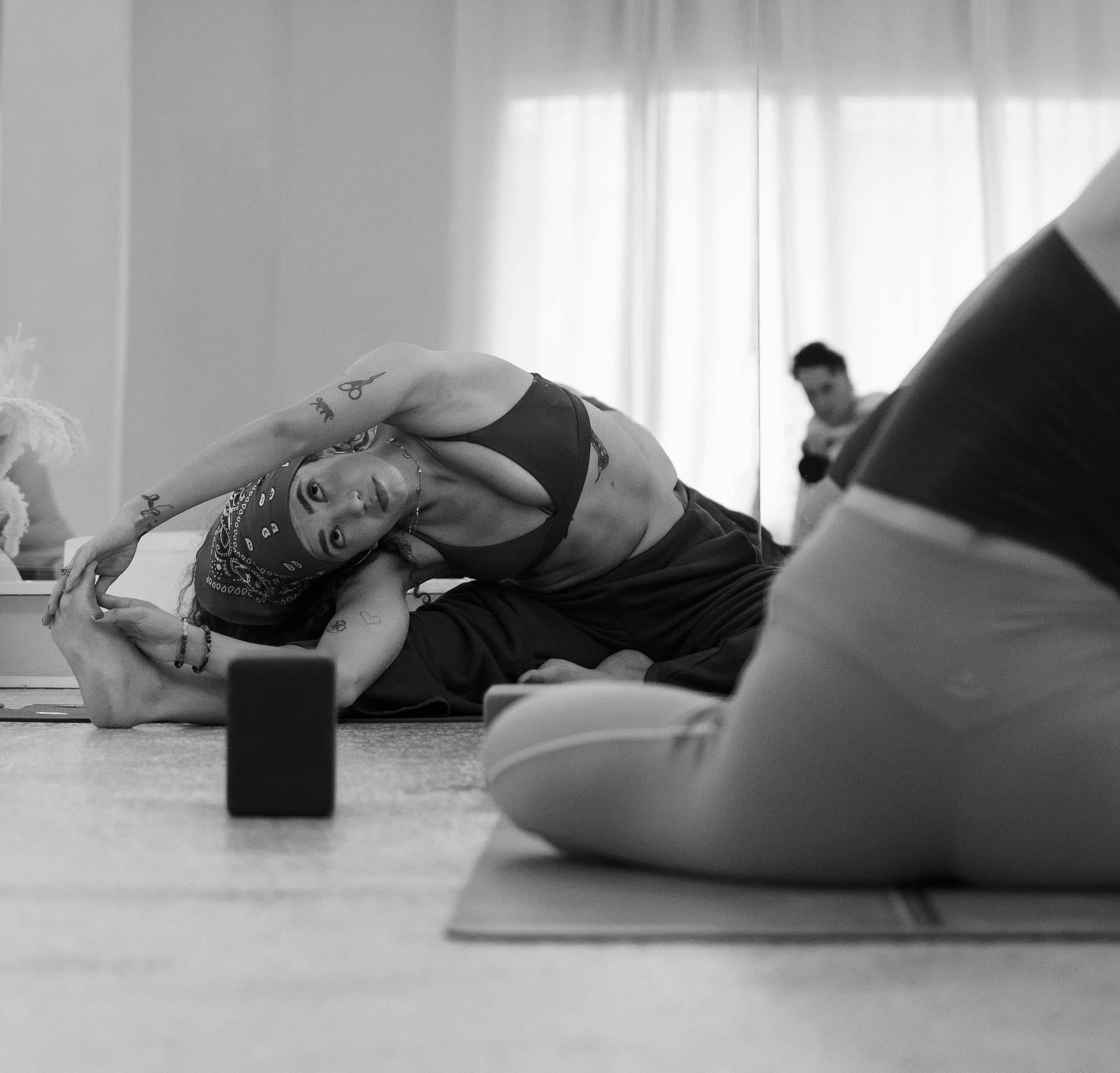 Ale in a seated side stretch during a studio class