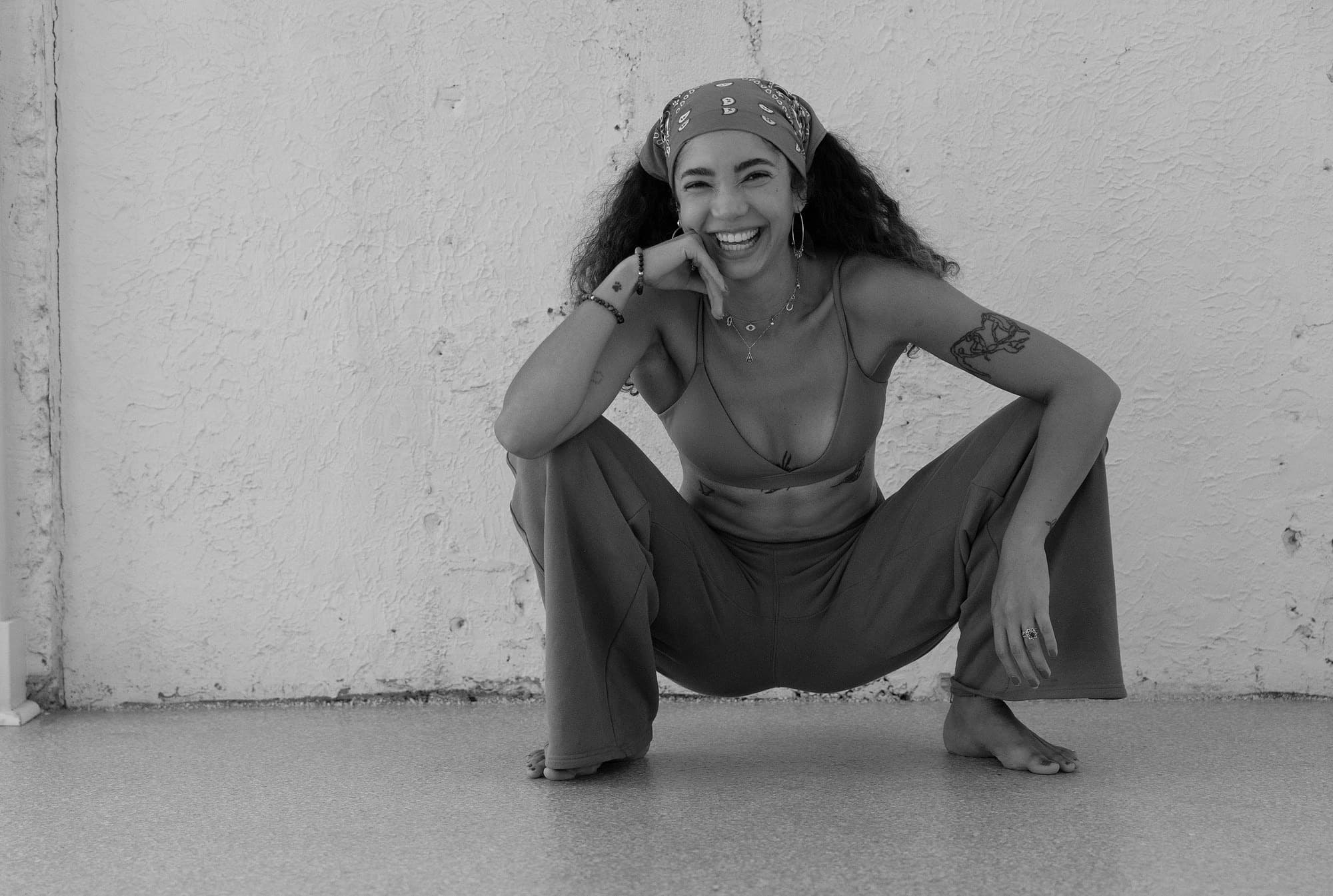 Ale in a low squat, laughing